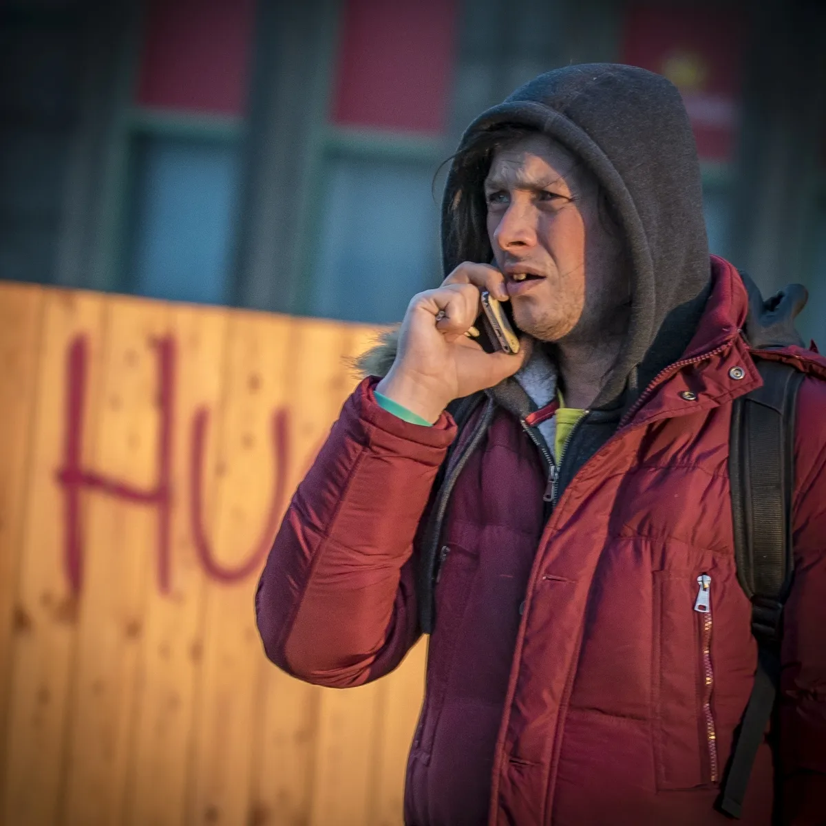 Man in a red jacket speaking on a mobile phone